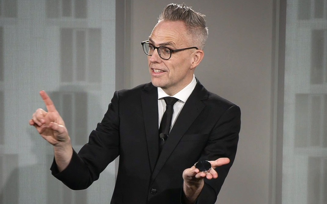Rune Carlsen presenterer magi med begge hendene synlig under et profesjonelt innslag.