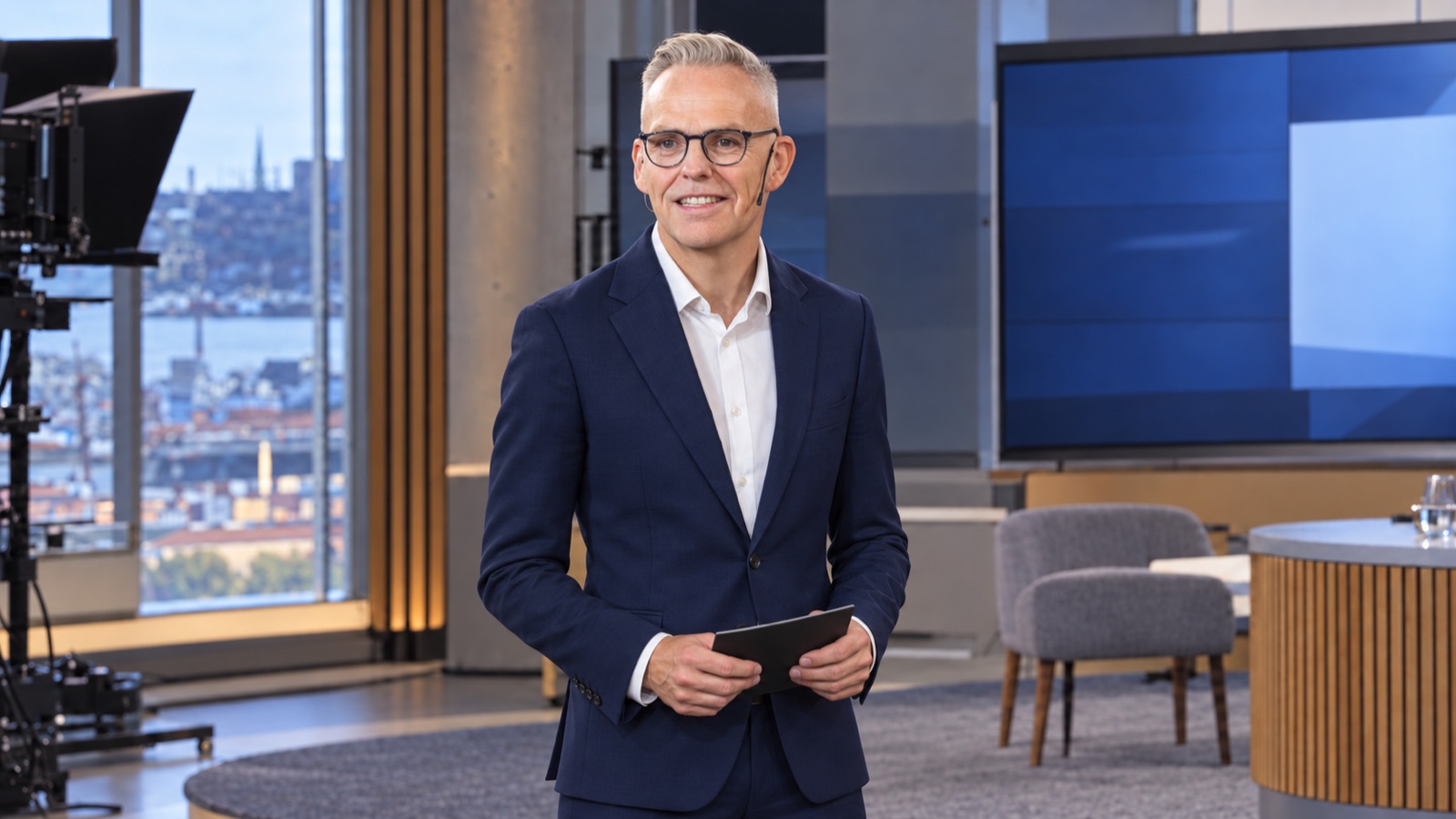 Rune Carlsen som programleder med headset og programkort i et TV-studio.
